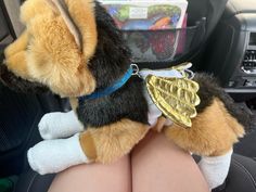 a stuffed animal sitting in the front seat of a car with its legs crossed out