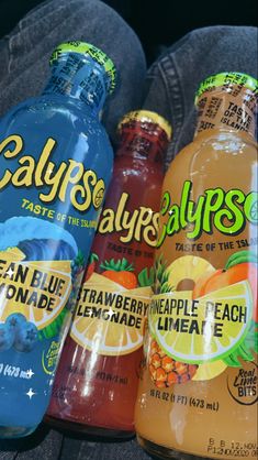 three bottles of calyps are sitting next to each other on the floor in front of someone's feet