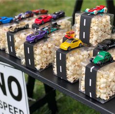 there are many cars and trucks on the table with popcorn in front of them,