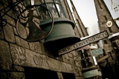 an old building with street signs and a bell hanging from it's front wall