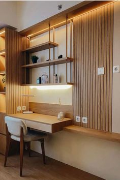 a desk and chair in a room with wood paneling on the wall behind it