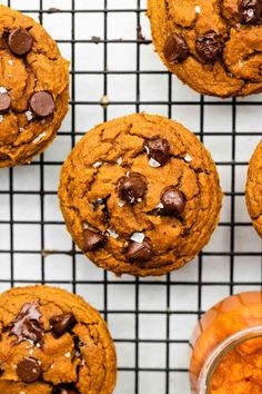 chocolate chip cookies cooling on a wire rack next to an orange bowl filled with powdered sugar