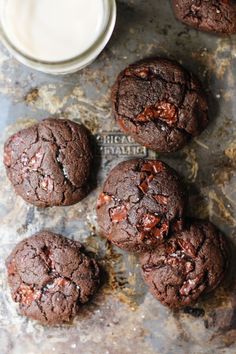 chocolate cookies and milk sitting on a table next to each other with the top one half eaten