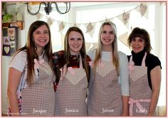 three women in aprons standing next to each other