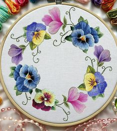 an embroidery kit with flowers and beads on it