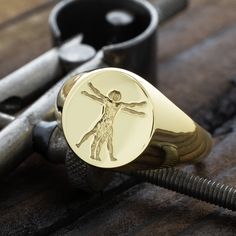 Elevate your style with our solid gold wax seal signet ring, featuring the iconic Vitruvian Man. Inspired by Leonardo da Vinci's masterpiece, this ring captures the essence of human perfection and the harmonious balance of body and mind. The Vitruvian Man, with his outstretched limbs encircled within a square and circle, symbolizes the ideal proportions of the human body as envisioned during the Renaissance. Crafted with meticulous detail, this wax seal signet ring is a tribute to the timeless pursuit of knowledge, art, and the human spirit, making it a perfect piece for those who appreciate the intersection of history, science, and beauty. This ring also comes with a high quality gift box with a message engraved on the top. You can write what you would like engraved in the notes section w The Vitruvian Man, Wax Seal Ring, 14k Gold Signet Ring, Gold Wax Seal, Vitruvian Man, Gold Signet Ring, Luxury Gift Box, Wax Seal, Wax Seals