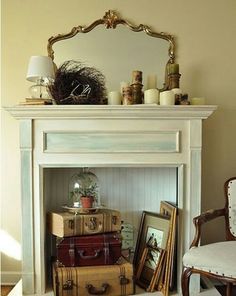 a white fireplace with suitcases stacked on top