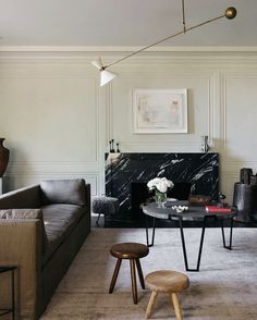 a living room filled with furniture and a fire place next to a wall mounted fireplace