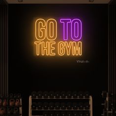 a neon sign that says go to the gym with dumbs in front of it