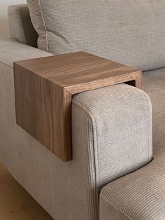 a close up of a couch with a wooden table on it's back end