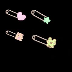 three different colored hair clips on a black background, one is shaped like a bear and the other has a heart