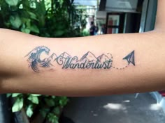 a person with a tattoo on their arm that says wanderlust and an arrow