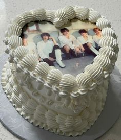 a heart shaped cake with an image of two young men in the middle on it