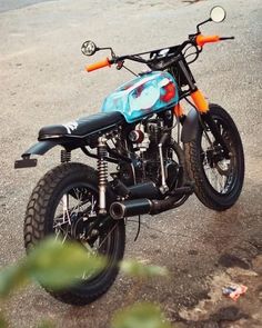 a blue and orange motorcycle parked on the street