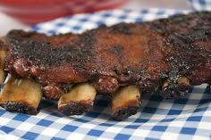 a piece of meat sitting on top of a blue and white checkered table cloth