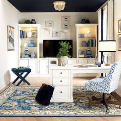 a living room filled with furniture and a flat screen tv on top of a white desk