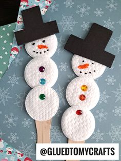 two snowmen made out of toilet paper on top of a wooden toothpick