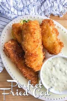 some fried food on a white plate with ranch dressing and dipping sauce in the bowl