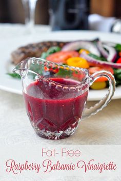 a glass pitcher filled with liquid sitting next to a plate of food on a table