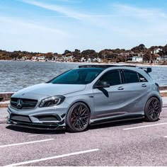 a mercedes cla is parked on the side of the road next to the water