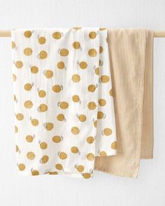 two towels hanging on a clothes line next to each other with yellow polka dot designs