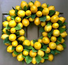 a wreath made out of lemons with green leaves on the front and side of it