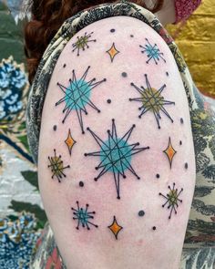 a woman's arm with stars and dots on the back of her left arm