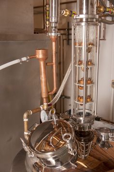 a machine that is sitting on top of a wooden table in a room with pipes