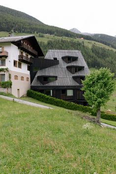 the building has many windows and balconies on it's sides, along with two trees