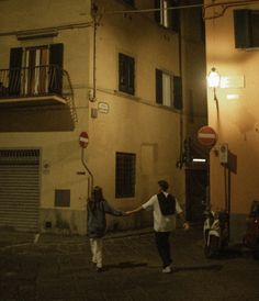 two people holding hands in the street at night