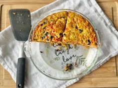 a piece of pizza on a plate with a spatula and knife next to it