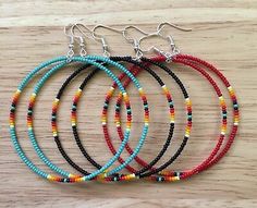 four bracelets with different colored beads on a wooden surface