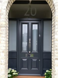 a black front door with flowers in the window