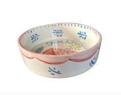 a small bowl with blue and red designs on the rim, sitting in front of a white background