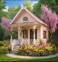 a small pink house with flowers in the front yard