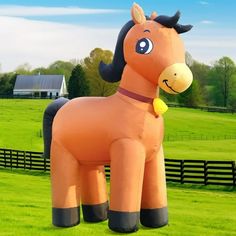 a large inflatable horse standing on top of a lush green field