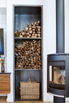 a wood burning stove in a living room next to a book shelf filled with logs