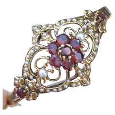 Vintage 14K Art Deco Hinged Bracelet 30s Garnet Seed Pearls Measurement: Oval hinged 2.25 inch by 2 inch Jewels: 9 round Garnet approximately 2.52 Carat Total weight, 1.5mm - 3.0mm white round Seed Pearls (one missing) Weight: 20.6 gram Country of origin: United States Hallmark: "14K" Antique Hallmarked Gold Bracelet For Wedding, Victorian Bracelets With 17 Jewels For Evening, Antique Gold Hinged Bracelet For Wedding, Antique Gold Bracelet For Wedding, Antique Hinged Gold Bracelet For Wedding, Victorian Bracelets For Anniversary, Victorian Screw Back Wedding Jewelry, Antique Evening Bracelets, Ornate Hinged Jewelry For Wedding