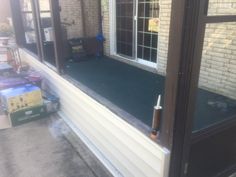 the back porch of a house with an open door and window on it's side