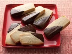 several pieces of chocolate dipped shortbread on a red plate