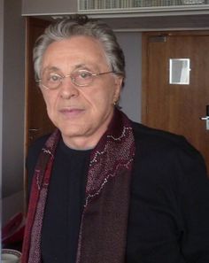 an older man wearing glasses and a scarf