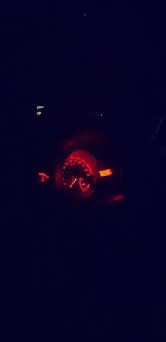 a car's speedometer in the dark with its lights turned on at night