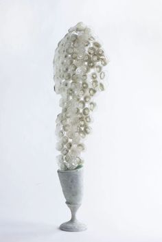 a white vase with pearls in it sitting on a table