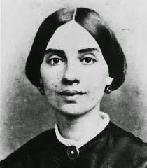 an old black and white photo of a woman with short hair wearing a leather jacket