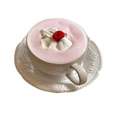 a cupcake with cream and a cherry on top is sitting on a saucer