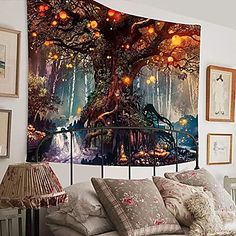 a bed room with a neatly made bed and a large tree tapestry on the wall