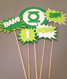 some green and white cupcake toppers on sticks with the number one in them