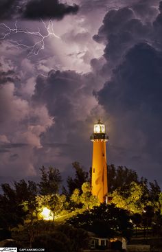 a light house with lightning in the background