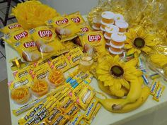 sunflowers and candy are displayed on a table with snacks, candies, and other items