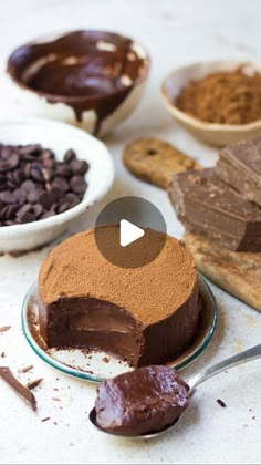 chocolate cake on a plate with spoon next to it and bowls of cocoa in the background